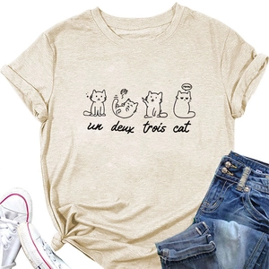 Flat lay of an apricot cat print T-shirt styled with denim shorts and canvas sneakers