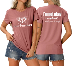 Vue détaillée du t-shirt rose poudré avec graphisme imprimé et slogan au dos du vêtement
