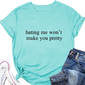 Flat lay of cyan T-shirt with slogan, knotted hem, denim jeans and white sneakers