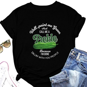 Flat lay of black T-shirt featuring green pickle print with denim jeans and sneakers