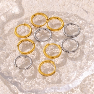 PVD gold titanium steel hoop earrings with cubic zirconia stones on glass tray