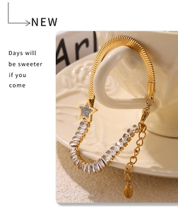Detail of gold-plated stainless steel bracelet with square zircon and star charm on a cup