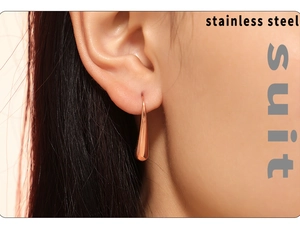 Primer plano de pendientes de gota de acero inoxidable en color oro rosa