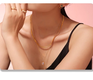 Nahaufnahme der zweilagigen Goldkette mit Zirkonia-Anhänger und Schlangenkette am Model