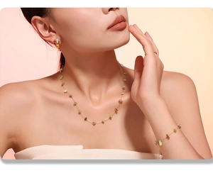 Detail of bohemian gold jewelry set featuring light green natural stones on a female model
