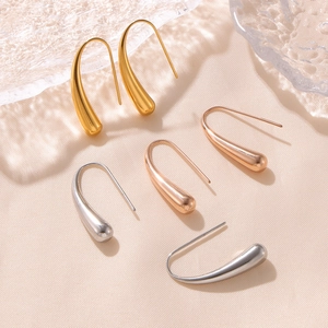 Pendientes minimalistas de gota de agua en oro, oro rosa y plata sobre fondo de seda