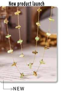 Detailed shot of handmade necklace with light green natural stone beads and gold chain