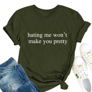 Detail of olive green t-shirt with slogan print paired with ripped jeans and sneakers