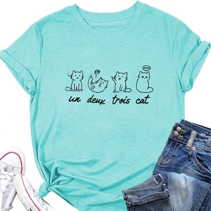 Detail of mint green t-shirt with un deux trois cat print and flat lay styling