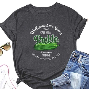 Flat lay of gray T-shirt with pickle graphic paired with denim shorts and sunglasses