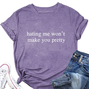 Detail of cotton t-shirt with slogan print and denim pants in a casual flat lay