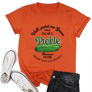 Flat lay of orange cotton T-shirt featuring funny green pickle graphic and humorous quote