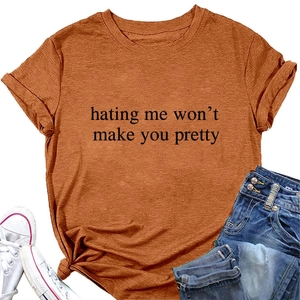 Close-up of caramel orange crewneck tee with hating me won't make you pretty slogan