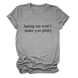 Detail of grey crewneck t-shirt with slogan 'hating me won't make you pretty' print