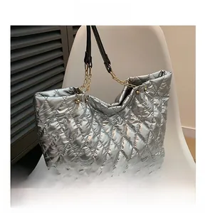Detail shot of the metallic silver tote bag with quilted pattern and chain strap