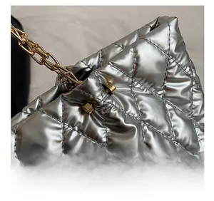 Close-up of silver quilted tote bag showing precise stitching and gold chain strap