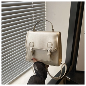 Detail of cream white leather backpack with dual buckle straps and textured surface