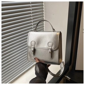 Detailed shot of a metallic silver mini satchel bag with double buckle closure