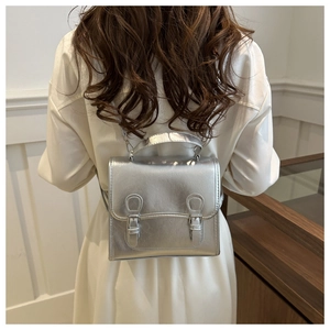 Silver metallic leather backpack shown on model highlighting the adjustable straps and buckles