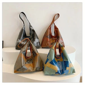 Retro patchwork tote bags in four colors displayed on a modern white stand