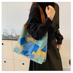 Detail view of the multi-color tote bag showing the patchwork leather and side profile