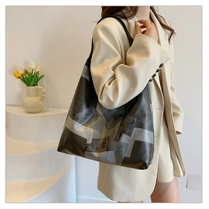 Detail of color-block leather tote bag featuring geometric layers and large capacity