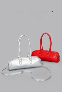 Detailed view of glossy leather baguette bags in silver and red with slim handles