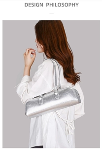 Detail view of silver cylindrical baguette bag with metallic texture on white shirt