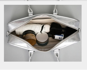 Top-down view of spacious silver tote interior with various daily items and zip pockets