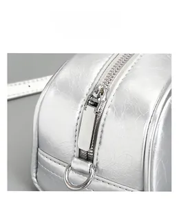 Close-up of smooth silver metal zipper and D-ring on minimalist silver leather handbag