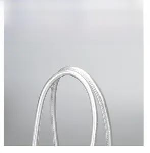 Detail of silver oil-wax leather baguette bag handle with precise stitching