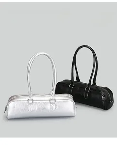 Detail of minimalist baguette shoulder bags in metallic silver and classic black finishes