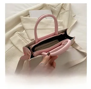 Spacious interior of beige canvas tote bag with pink leather trim showing daily storage
