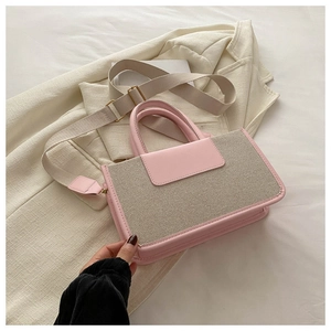 Detailed shot of pink and beige woven tote bag on beige blazer with adjustable shoulder strap