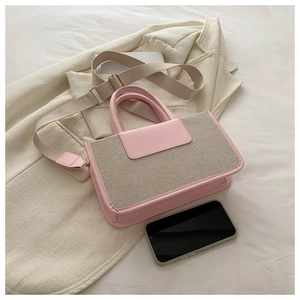 Pink PU leather and beige canvas crossbody bag detail with wide woven strap and smartphone scale