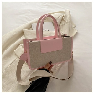 Detail of pink leather and beige canvas patchwork tote bag with wide textile strap