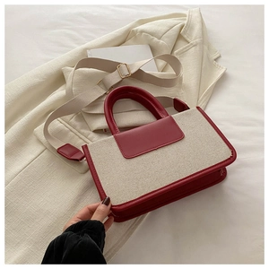 Detail of red and cream canvas tote bag with leather trim and wide shoulder strap