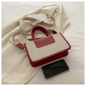 Mini red and beige canvas tote bag with leather trim and wide woven strap on a blazer