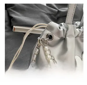 Détail du sac en cuir métallisé argenté avec chaîne en perles et charm papillon