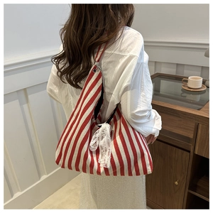 Detail showing red and white striped canvas tote with elegant white lace bow decoration