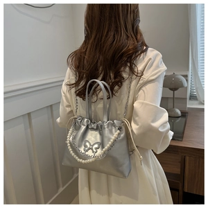 Sac argenté métallisé avec détails papillon et élégante poignée en chaîne de perles