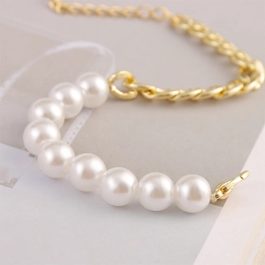 Detalle de pulsera de perlas barrocas con elegante cadena dorada y perlas blancas
