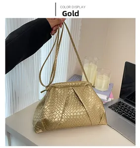Detail of gold woven cloud bag showing texture and slim shoulder strap in a cozy setting