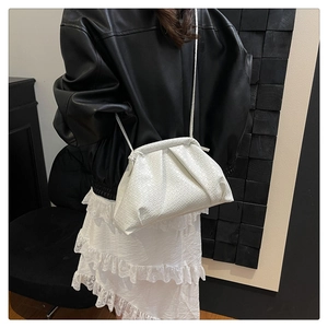 Detail of white dumpling cloud bag with crocodile texture and thin shoulder strap