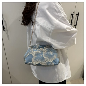 Detail view of the vintage blue floral jacquard fabric and golden metal chain strap