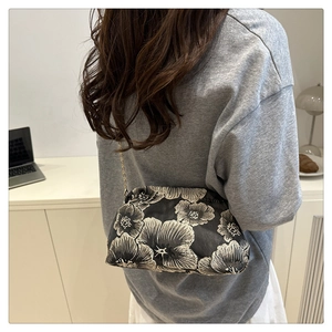 Detail of floral embroidery and gold chain on a vintage Chinese style shoulder bag