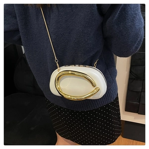 Detail of white leather oval chain bag with large gold metal ring and slim gold strap