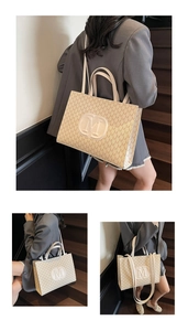 Gros plan d'un sac cabas beige avec motif monogramme M et écusson logo rond en cuir