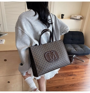 Détail du sac cabas monogramme avec logo M en relief et anses en cuir marron en intérieur