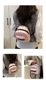 Detail of pink mini backpack with black bird print and metal fashion logo plaque